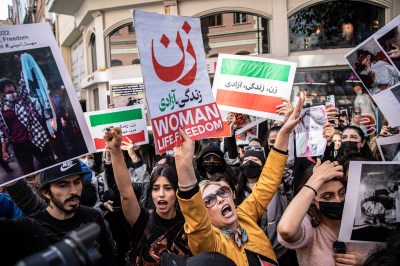 Protesters hold placards and chant slogans outside the Iranian Consulate in Istanbul during a protes...
