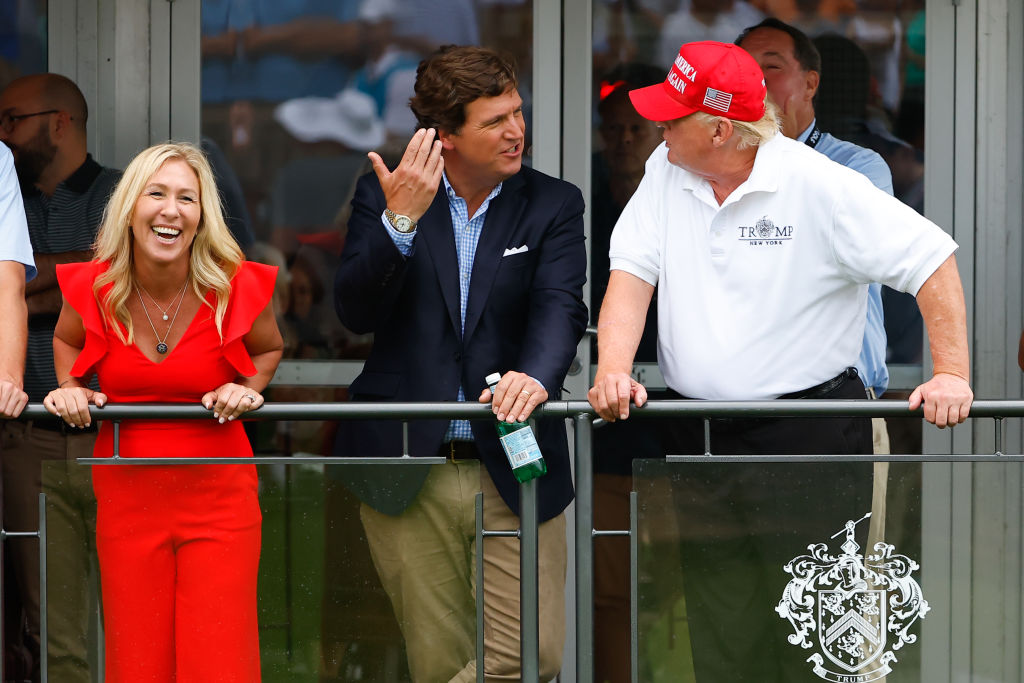 Marjorie Taylor Greene, Tucker Carlson, and former President Donald Trump. (Photo by Rich Graessle/Icon Sportswire/Getty Images.)