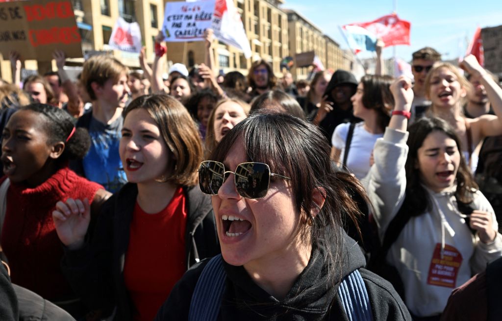 Youth in France take part in a demonstration Tuesday after the government pushed a pensions reform through parliament without a vote. (Photo by NICOLAS TUCAT / AFP) (Photo by NICOLAS TUCAT/AFP via Getty Images)