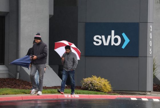 Employees walk outside of the shuttered Silicon Valley Bank (SVB) headquarters in Santa Clara, California. (Photo by Justin Sullivan/Getty Images)