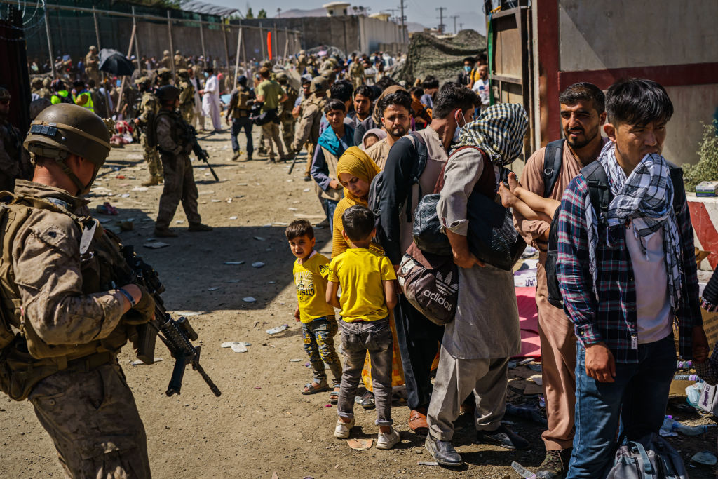 American soldiers watch over Afghan refugees waiting in line to be processed for an exit flight out of Kabul, Afghanistan, Wednesday, Aug. 25, 2021. (MARCUS YAM / LOS ANGELES TIMES)