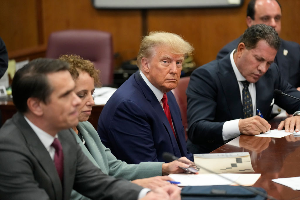 Former U.S. President Donald Trump sits with his defense team in a Manhattan court during his arraignment on April 4, 2023. (Photo by Seth Wenig-Pool/Getty Images)