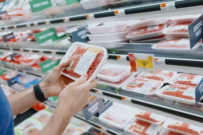 Man Checks Price of Ground Beef at Supermarket