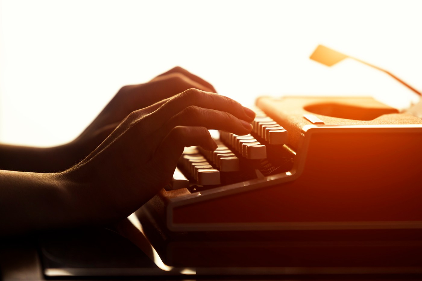 Close up shot of woman typing on old vintage retro typewriter.