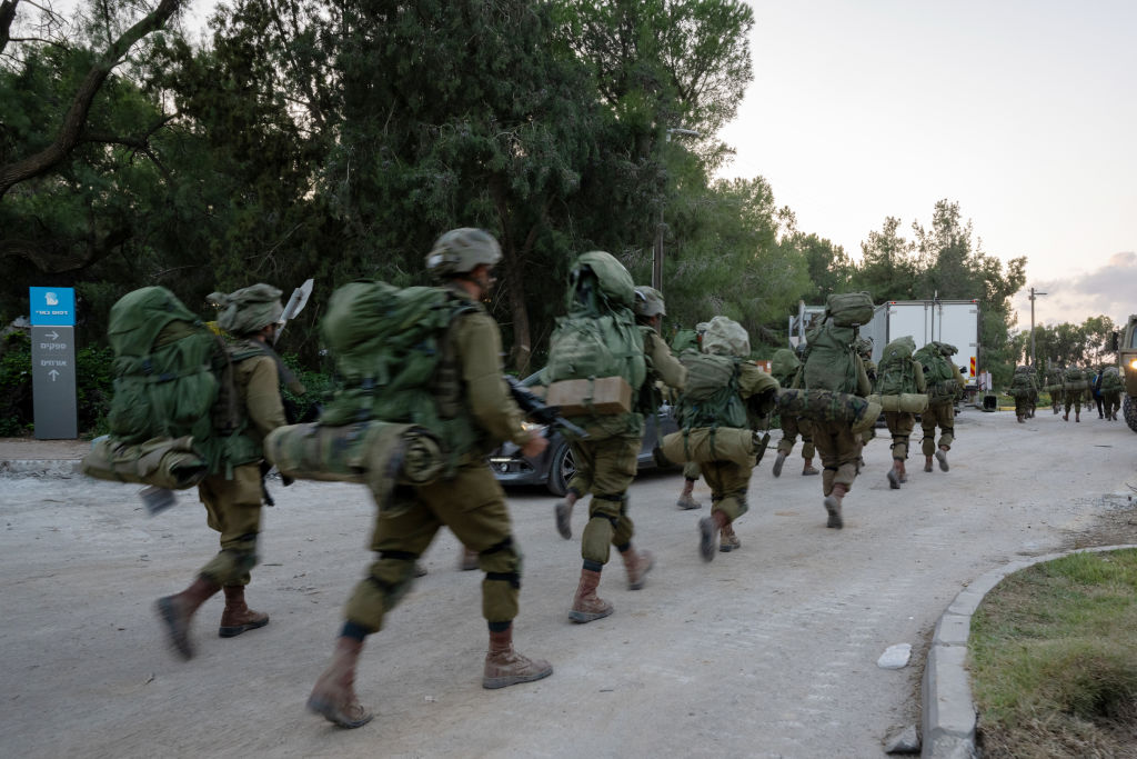 Israel Defense Forces soldiers walk through Kibbutz Be'eri where days earlier Hamas terrorists killed over a hundred civilians near the border with Gaza on October 11, 2023 in Be'eri, Israel. (Photo by Alexi J. Rosenfeld/Getty Images)