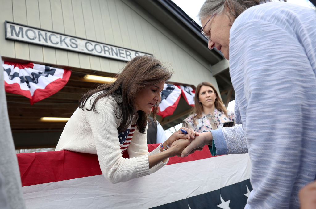 Republican presidential candidate former U.N. Ambassador Nikki Haley prays with a supporter during a campaign event on February 23, 2024, in Moncks Corner, South Carolina. (Photo by Justin Sullivan/Getty Images)