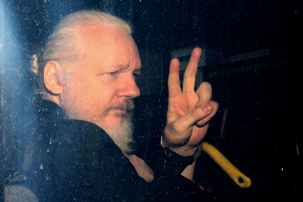 Julian Assange gestures to the media from a police vehicle on his arrival at the Westminster Magistrates Court in London on April 11, 2019. (Photo by Jack Taylor/Getty Images)
