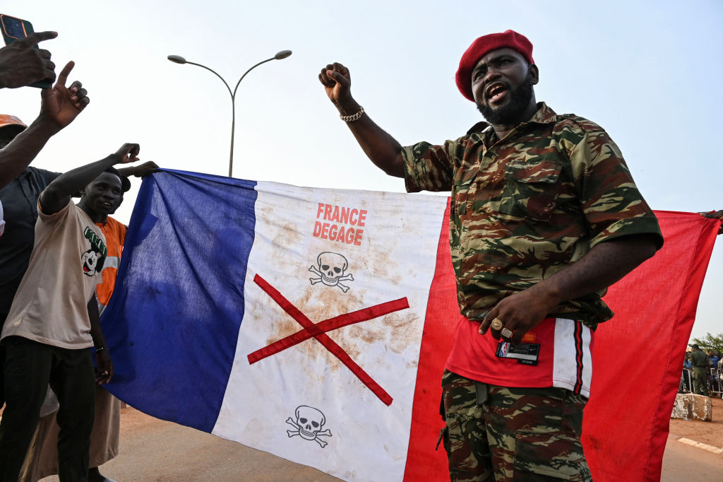 Supporters of Niger's National Council for the Safeguarding of the Homeland (CNSP) display a French national flag with an X-mark during a protest outside a French airbase in Niamey demanding the departure of the French army from Niger on September 1, 2023. (Photo by AFP) (Photo by -/AFP via Getty Images)