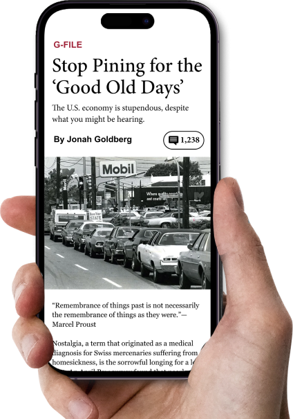 A hand holding a cellphone with an article from The Dispatch displayed.