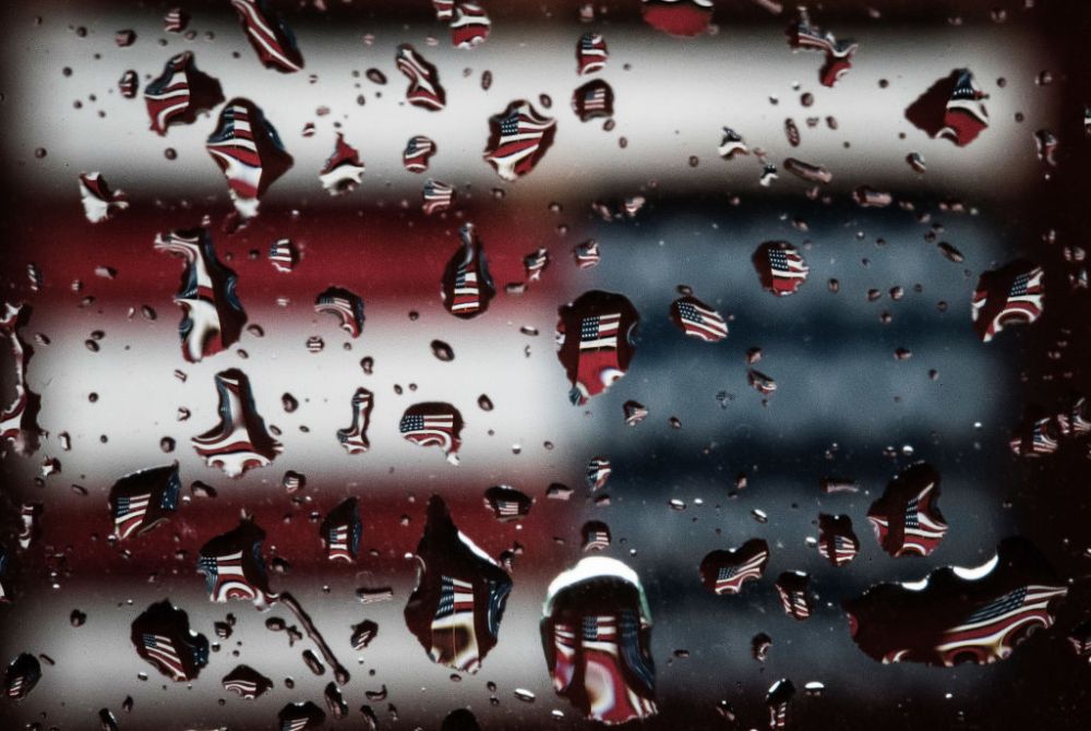 The inverted image of an American flag on the Butte Valley Museum is refracted in raindrops on a car window during a rainstorm in the Klamath Basin outside Dorris, Calif., on Sunday, May 17, 2020. Nowhere has California’s dry winter hit harder than the s