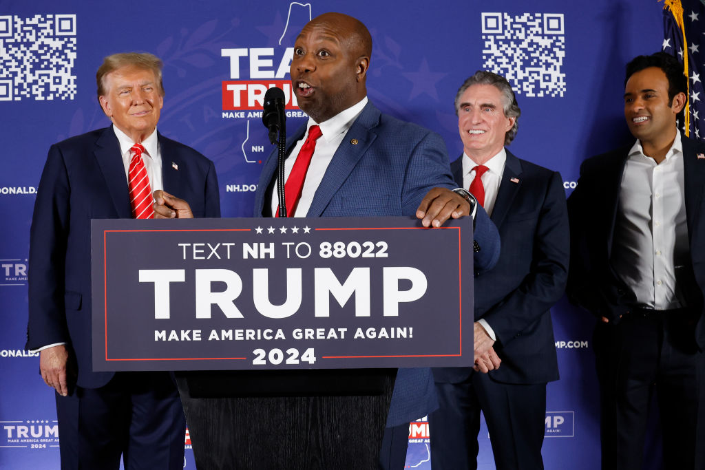 Sen. Tim Scott speaks as former President Donald Trump, North Dakota Gov. Doug Burgum, and Vivek Ramaswamy look on during a campaign rally in the basement ballroom of the Margate Resort in Laconia, New Hampshire, on January 22, 2024. (Photo by Chip Somodevilla/Getty Images)