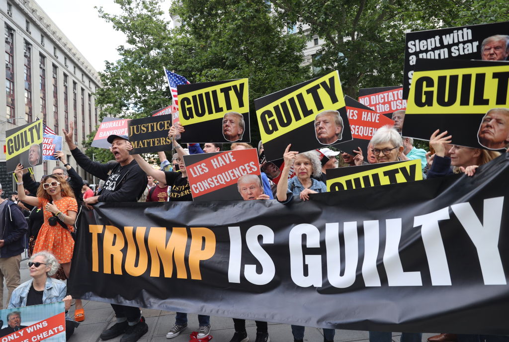 Demonstrators gather with banners after Donald Trump was found guilty in his New York criminal trial on May 30, 2024. (Photo by Selcuk Acar/Anadolu via Getty Images)