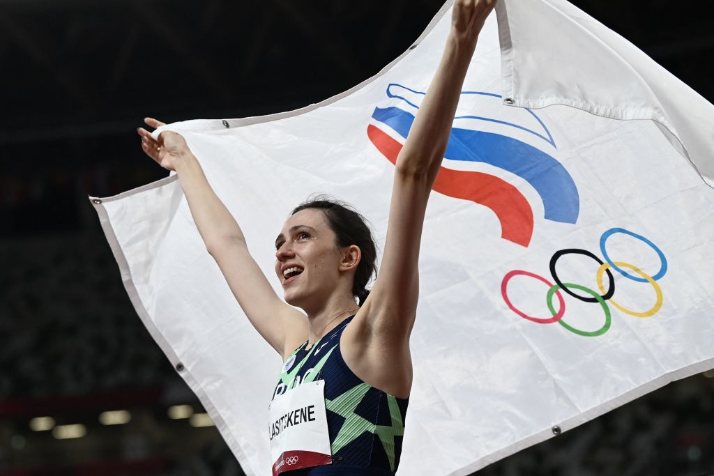 Russia's Mariya Lasitskene celebrates with the Russian Olympic Committee flag after winning the women's high jump goal medal during the Tokyo 2020 Olympic Games on August 7, 2021. (Photo by JEWEL SAMAD/AFP via Getty Images)