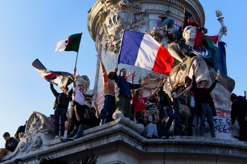 People celebrate on the statue of Marianne on the Place de la Republique in Paris, France, after an alliance of left-wing parties had a successful election on July 7, 2024. (Photo by Remon Haazen/Getty Images)