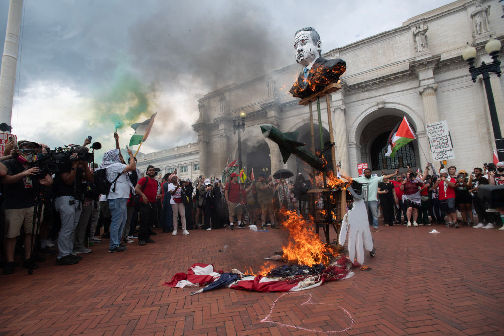 Protesters burn an American flag outside of Union Station in Washington, D.C., following Israeli Prime Minister Benjamin Netanyahu's address during a joint session of Congress on July 24, 2024. (Photo by MATTHEW HATCHER/AFP via Getty Images)