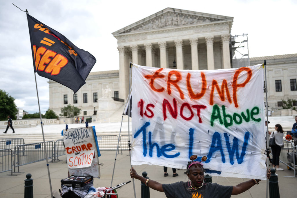 People hold anti-Trump signs in front of the Supreme Court building on July 1, 2024, in Washington, D.C. (Photo by DREW ANGERER/AFP via Getty Images)