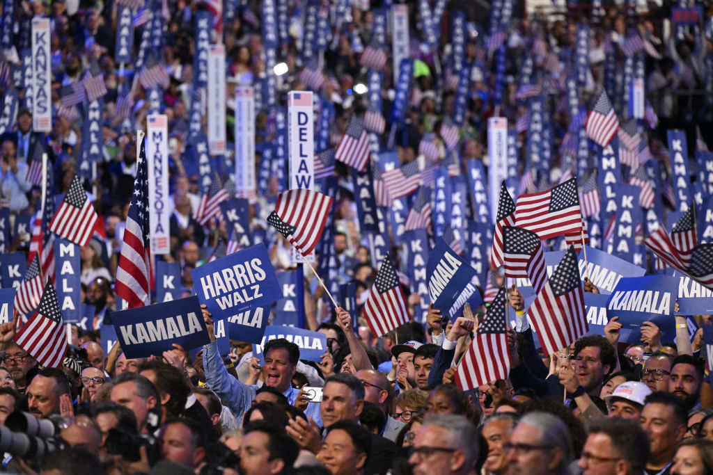 Delegates hold signs and wave American flags on the fourth and final day of the Democratic National Convention at the United Center in Chicago, Illinois, on August 22, 2024. (Photo by ROBYN BECK/AFP via Getty Images)