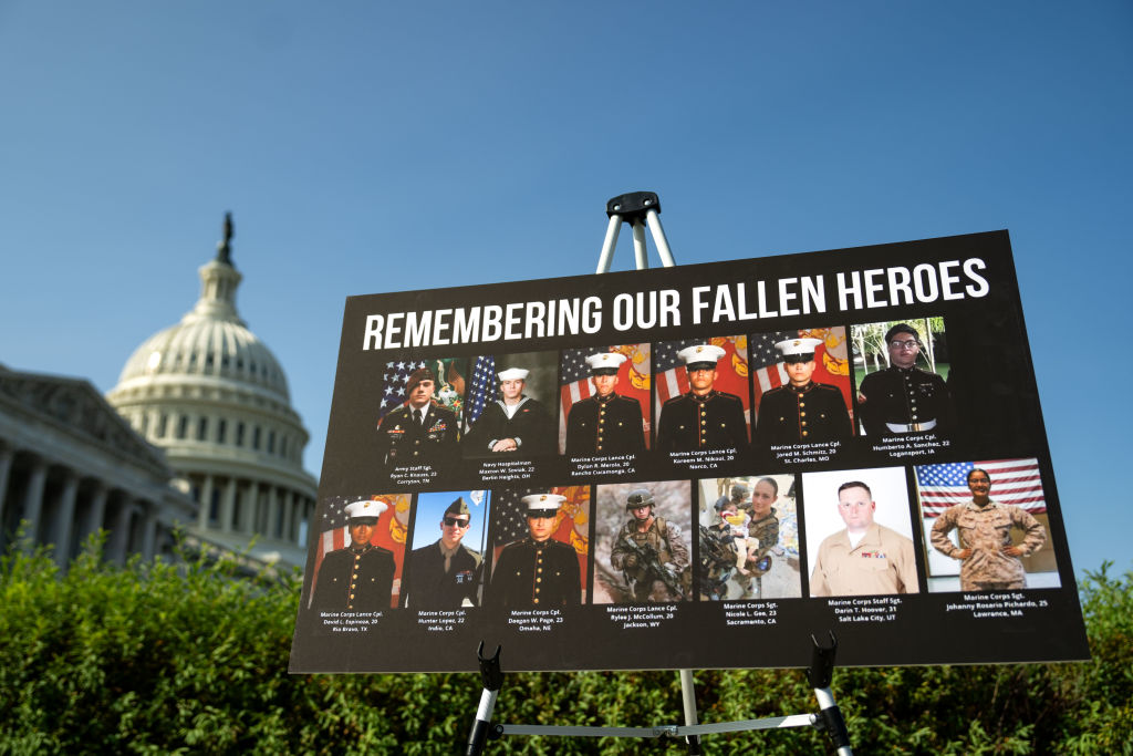 A sign displaying photos and names of the 13 service members killed in a terrorist attack at Abbey Gate outside Kabul's Hamid Karzai International Airport is displayed during a news conference at the U.S. Capitol on September 9, 2024. (Photo by Kent Nishimura/Getty Images)