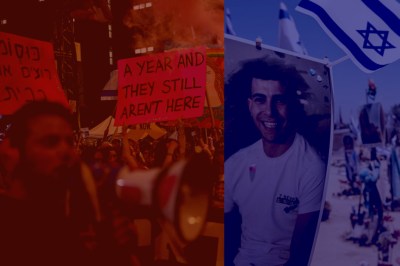 A woman pass among Israeli flags and signs depicting the