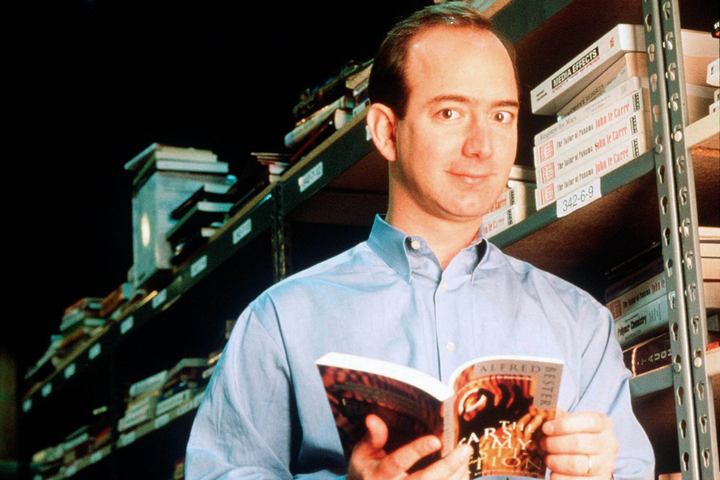 Jeff Bezos, the founder of Amazon, poses with a book in an Amazon warehouse in Seattle, Washington, on January 1, 1997. (Photo By Paul Souders/Getty Images)