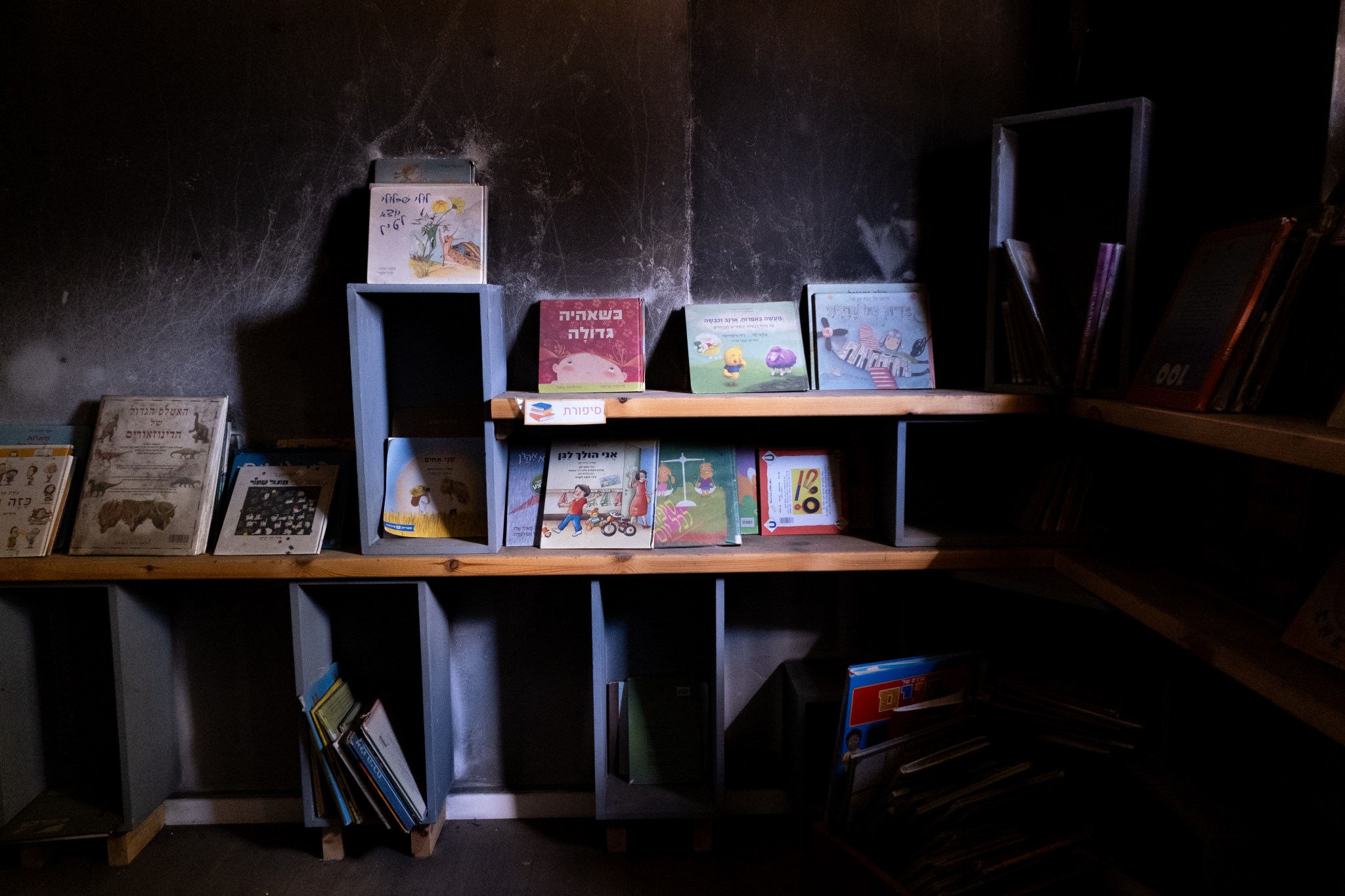 Shelves of children’s books line the wall in the kindergarten at Nir Oz that was partially torched by Hamas on October 7. (Photo by Charlotte Lawson.)