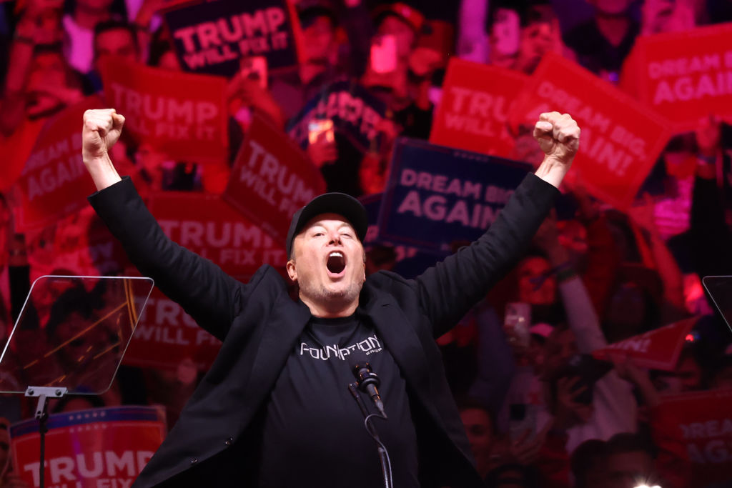 Tesla and X CEO Elon Musk raises his hands as he takes the stage during a campaign rally for former President Donald Trump at Madison Square Garden on October 27, 2024, in New York City.  (Photo by Michael M. Santiago/Getty Images)