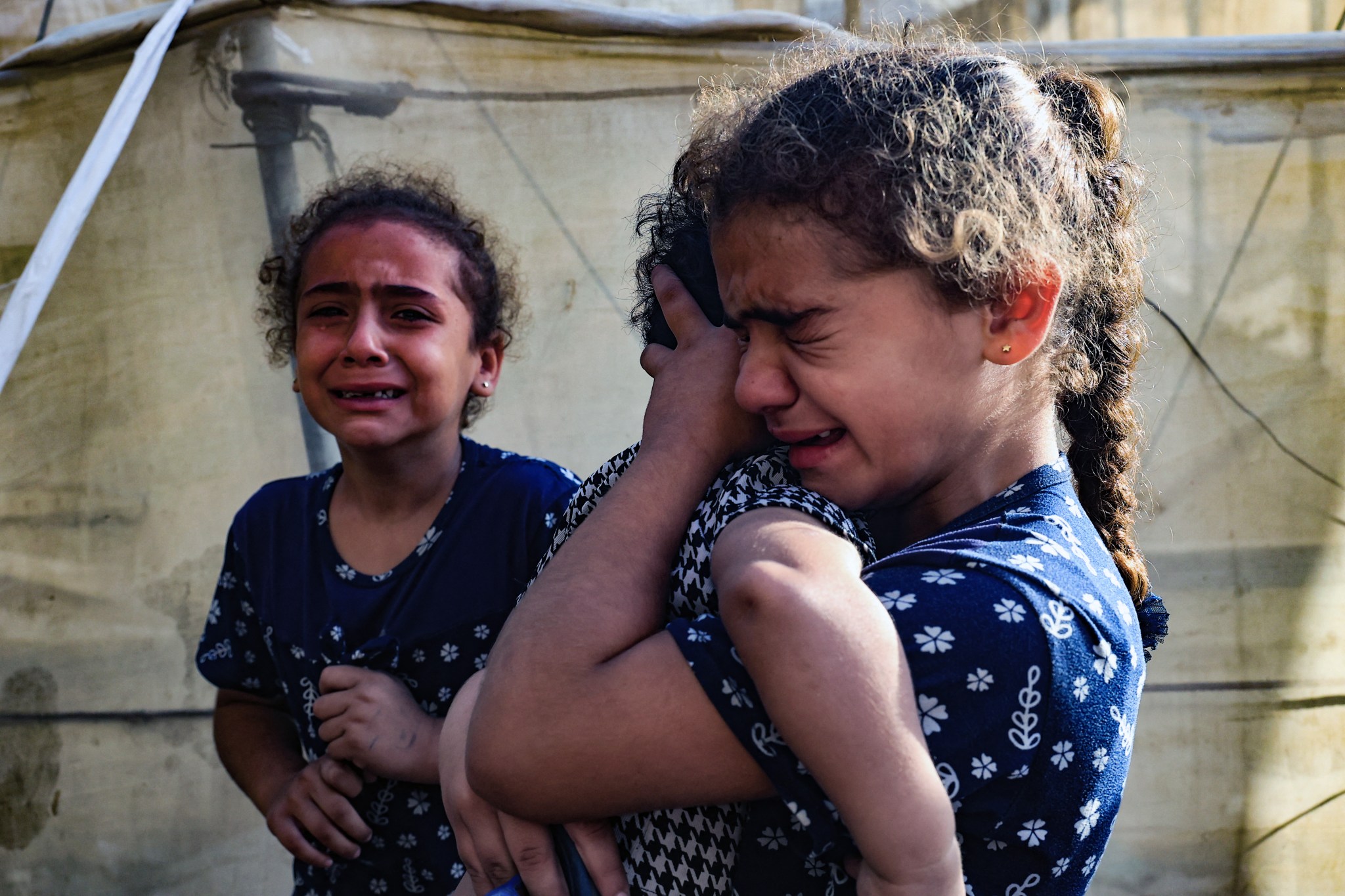 Children react during the November 11, 2023, funeral of a family killed by an Israeli airstrike in Rafah. (Photo by SAID KHATIB/AFP via Getty Images)