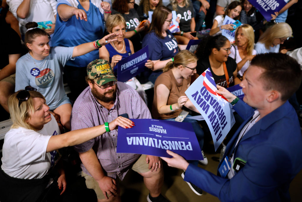 Volunteers hand out signs to supporters as they wait for the arrival of Democratic presidential nominee, Vice President Kamala Harris on September 13, 2024, in Wilkes Barre, Pennsylvania. (Photo by Chip Somodevilla/Getty Images)