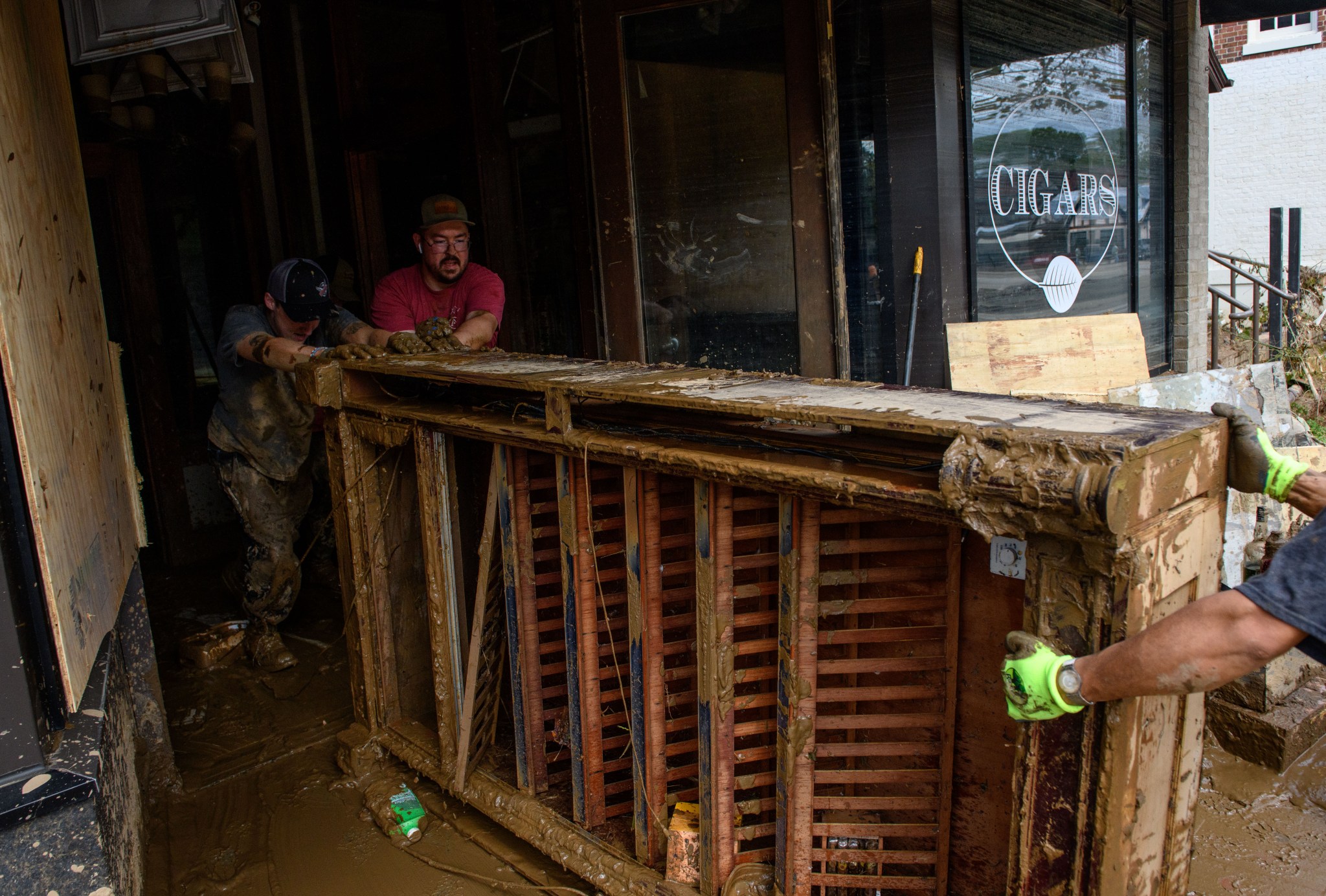 ASHEVILLE, NORTH Volunteers help remove a shelving unit from the Casablanca Cigar Bar at the Biltmore Village across from the Biltmore Estate in Asheville, North Carolina, in the aftermath of Hurricane Helene on October 1, 2024. (Photo by Melissa Sue Gerrits/Getty Images)