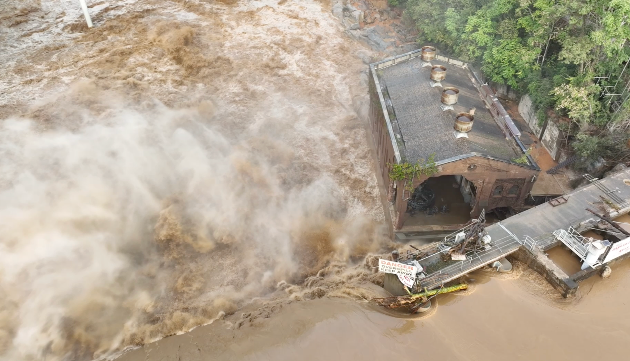 Water pours over the 111-year-old Nolichucky Dam after Hurricane Helene dumped record rainfall on western North Carolina and eastern Tennessee. (Screen grab from TVA drone footage)