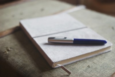 Pen and journal on suitcase