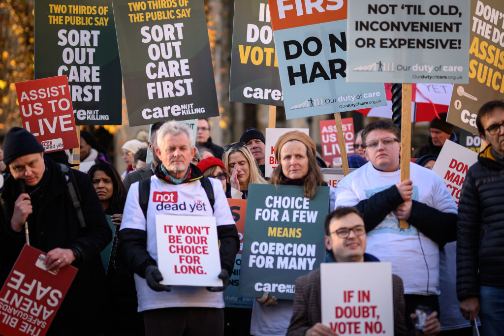 Supporters of the "Not Dead Yet" campaign, which opposes assisted dying, react outside the Houses of Parliament as news breaks that Parliament passed a bill in favor of the practice on November 29, 2024, in London, England. (Photo by Leon Neal/Getty Images)