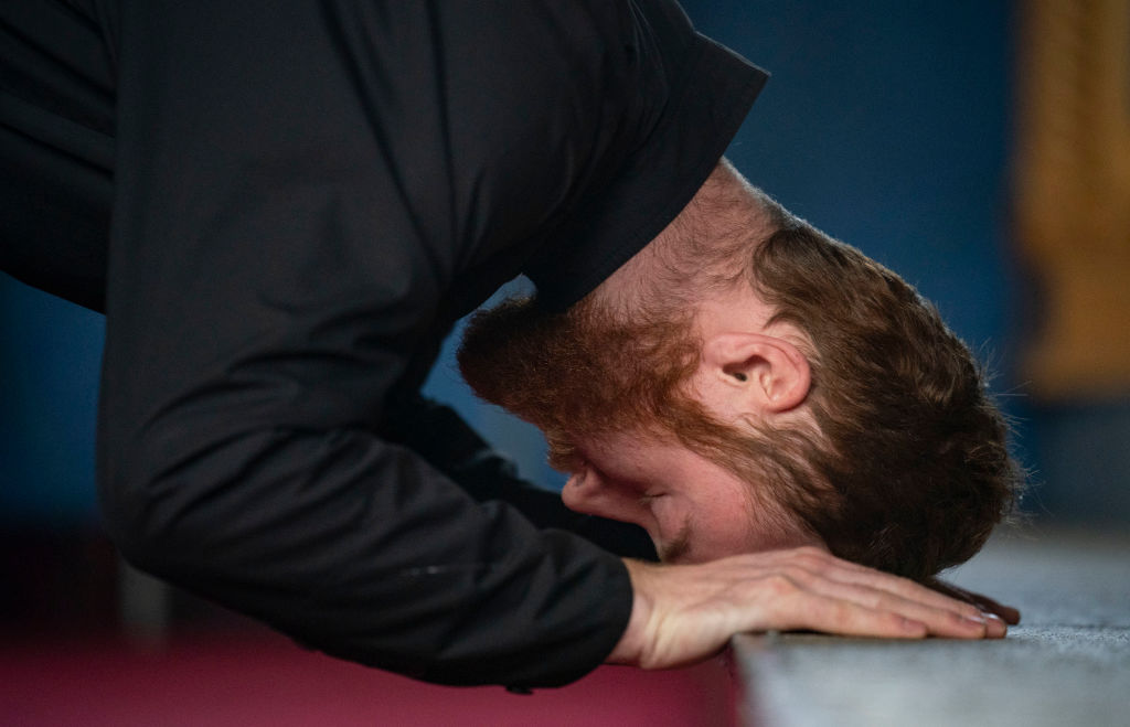 Steven Thell bows before the icon of Christ nailed to the cross during Good Friday vespers of the unnailing.  (Photo by Alex Kormann/Star Tribune via Getty Images)