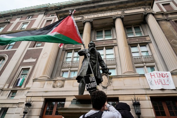 A student protester parades a Palestinian flag outside the entrance to Hamilton Hall on the campus of Columbia University on April 30, 2024, in New York City. (Photo by Mary Altaffer-Pool/Getty Images)