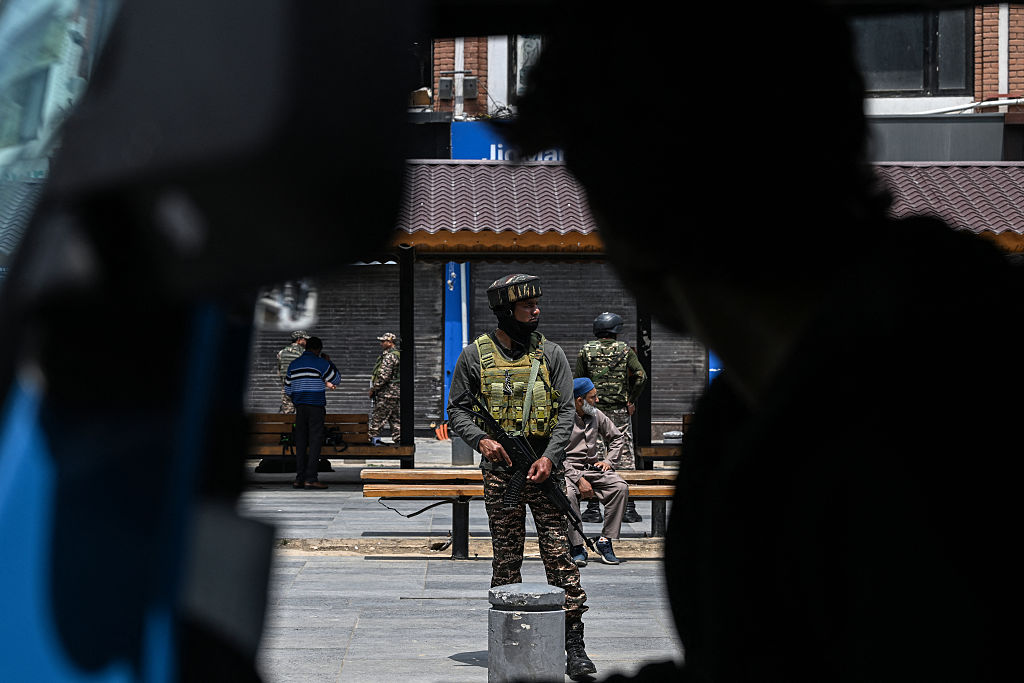 A rickshaw driver waits for passengers as an Indian paramilitary soldier keeps guard along a street in Srinagar on May 4, 2025. (Photo by SAJJAD HUSSAIN/AFP via Getty Images)