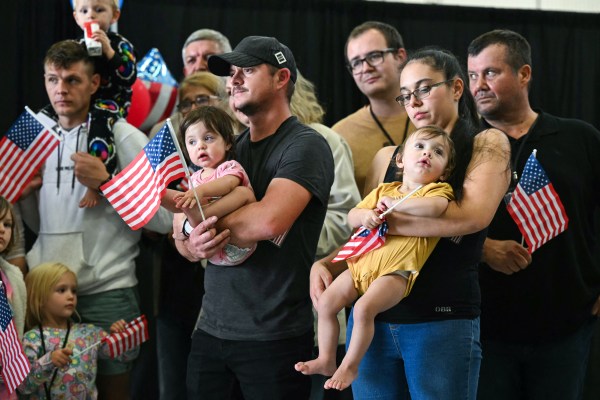 The first group of Afrikaners from South Africa to arrive for resettlement in the U.S. listen to remarks from Deputy Secretary of State Christopher Landau after they arrived at Washington Dulles International Airport in Virginia on May 12, 2025. (Photo by Saul Loeb/AFP via Getty Images)