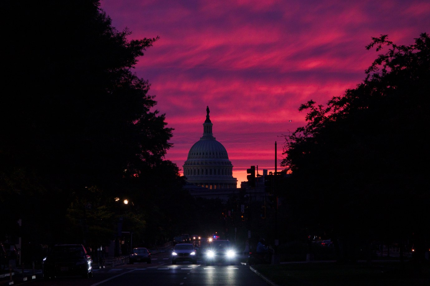 The sun sets behind the Capitol Building as vehicles drive down Pennsylvania Avenue on June 1, 2025, in Washington, D.C. (Photo by Kevin Carter/Getty Images)