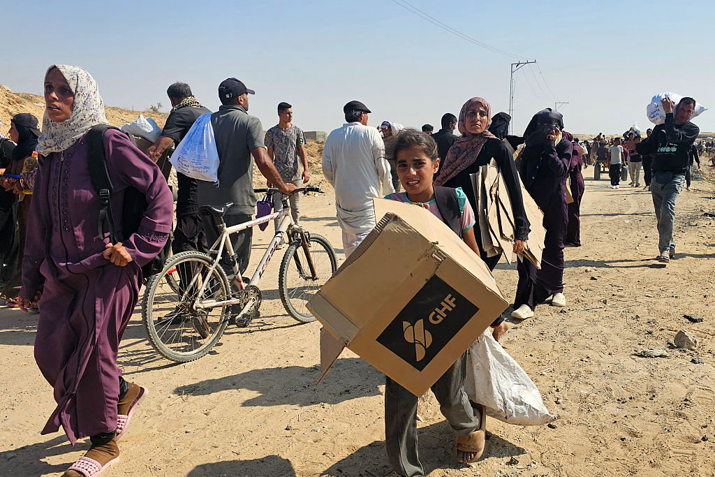 Palestinians walk along a road to receive humanitarian aid packages from the Gaza Humanitarian Foundation in Rafah on June 5, 2025. (Photo by AFP via Getty Images)