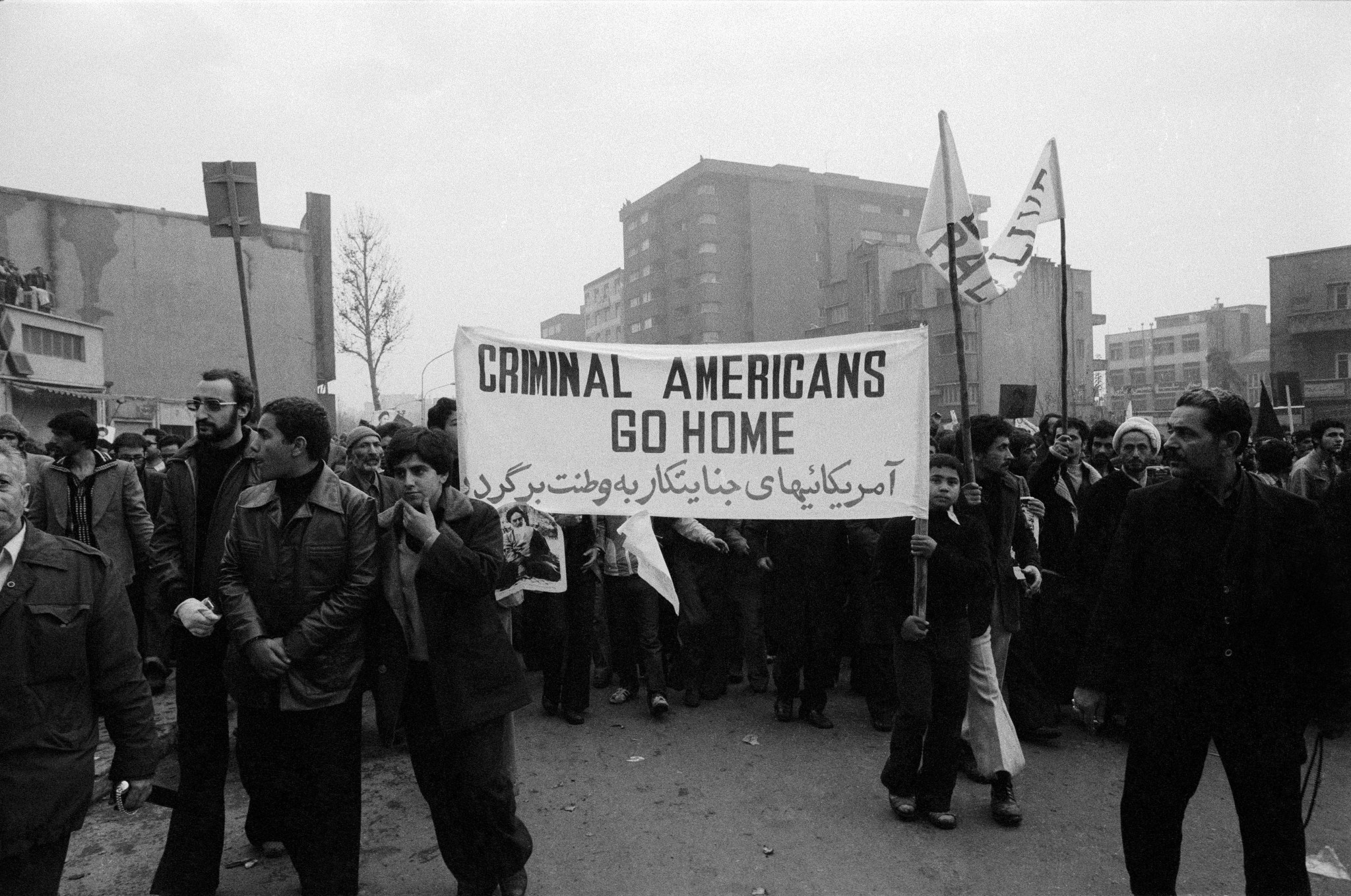 Demonstrators in Tehran carry a banner calling for "Criminal Americans Go Home" during the Iranian Revolution, on December 11, 1978. (Photo by Kaveh Kazemi/Getty Images)