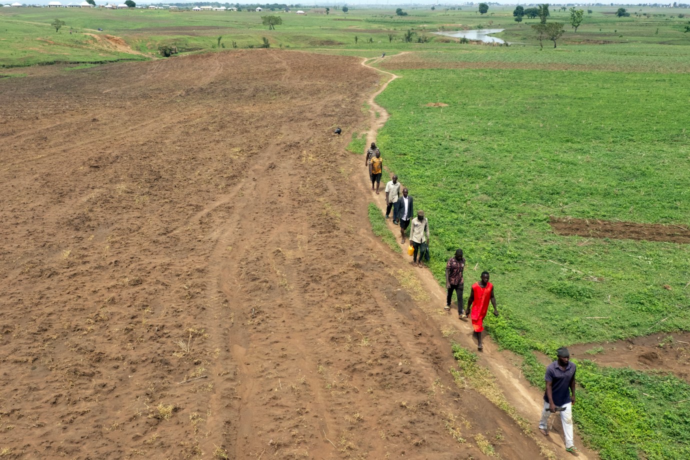 Farmers walk through farmland in the Paikon Kore community in Gwagwalada, Nigeria, on June 4, 2024. (Photo by Kola Sulaimon/AFP via Getty Images)