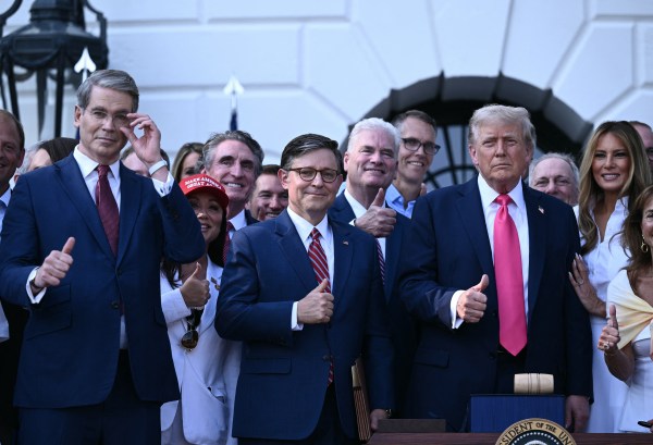 President Donald Trump poses with Treasury Secretary Scott Bessent, Interior Secretary Doug Burgum, House Speaker Mike Johnson, first lady Melania Trump, and others after signing the