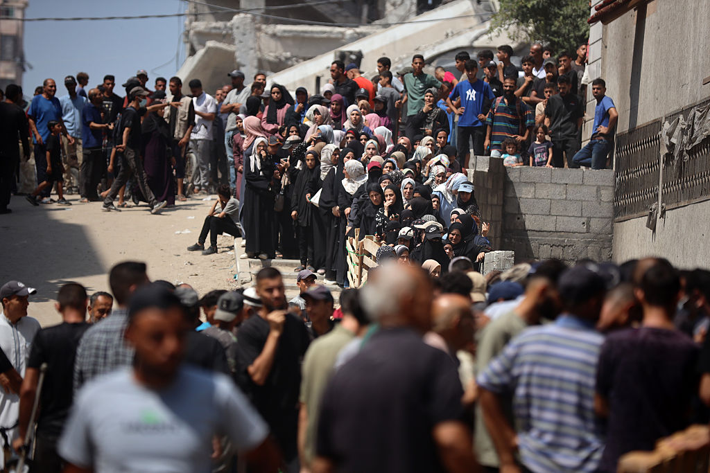 Palestinian women queue in front of a flour distribution point in Gaza City, on July 12, 2025. (Photo by Majdi Fathi/NurPhoto via Getty Images)