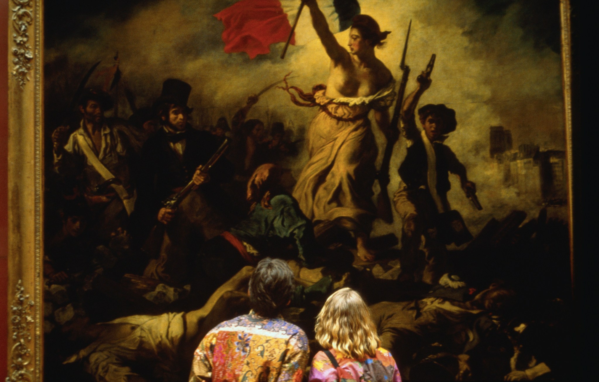 A couple views 'Liberty Leading the People' by Eugene Delacroix. (Photo by Farrell Grehan via Getty Images)