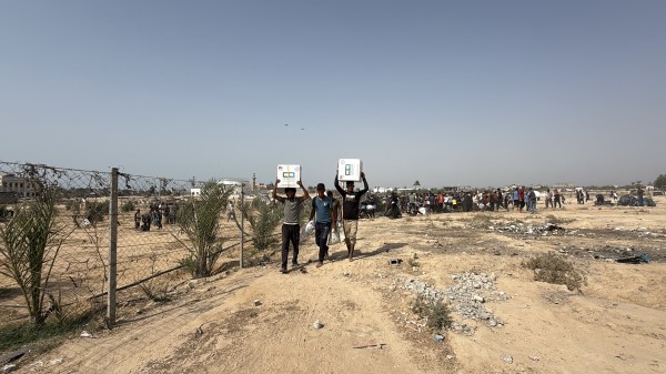Palestinians rush to collect humanitarian aid supplies airdropped by parachute over the central Gaza Strip city of Deir Al-Balah, amid ongoing Israeli attacks and blockade, on August 13, 2025. (Photo by Alaa Y. M. Abumohsen/Anadolu/Getty Images)
