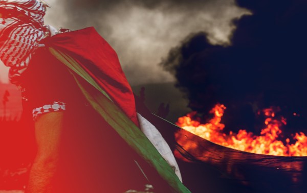 A Palestinian dons a Palestinian flag during while protesting Israeli occupation in the West Bank. (MARCUS YAM / LOS ANGELES TIMES)