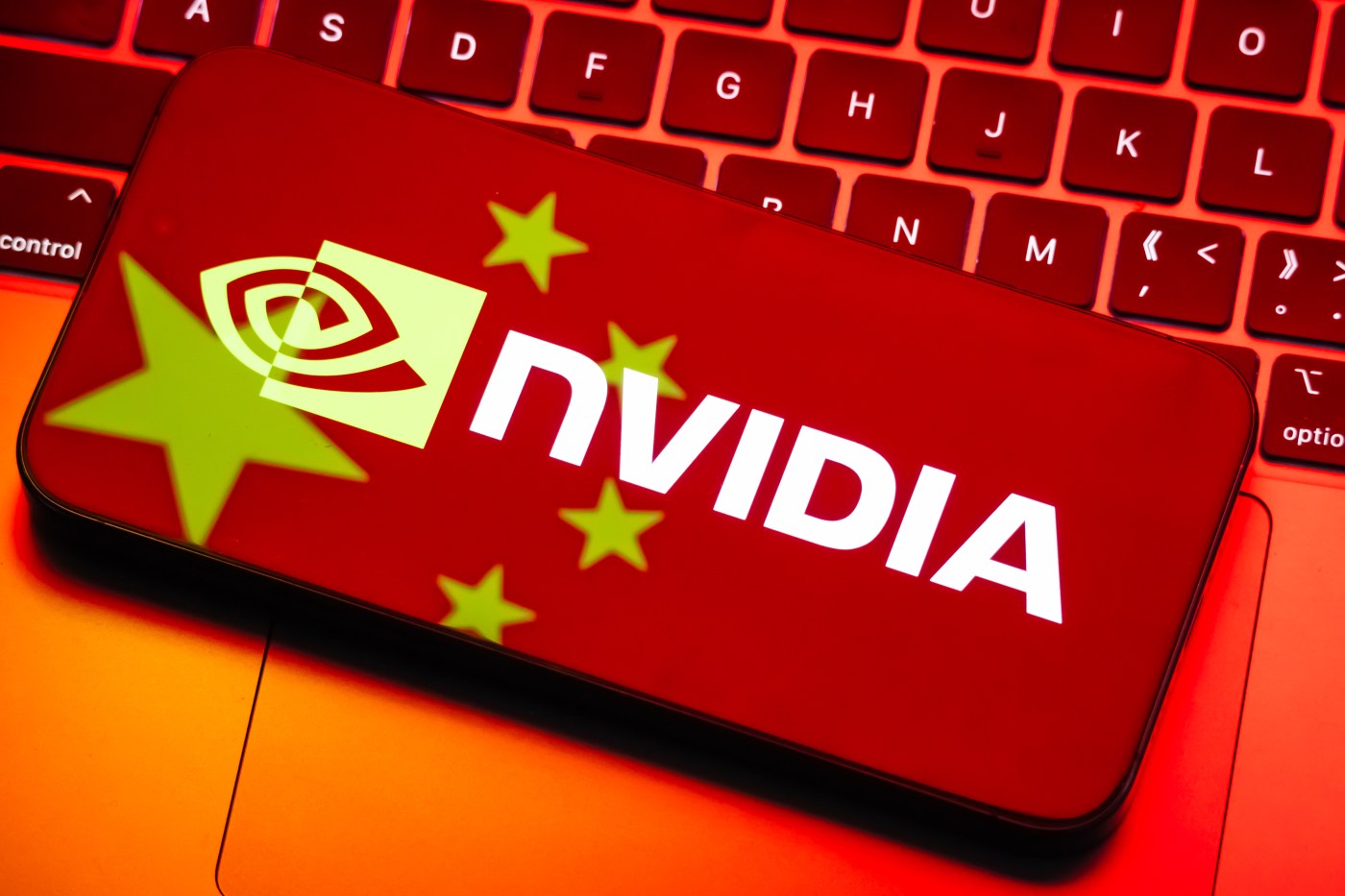 Nvidia logo displayed on smartphone with Chinese flag reflection from computer screen